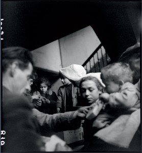 Distribution de biscuits et de chocolat par une religieuse dans un village alsacien libéré, Alsace le 6 janvier 1945 © ECPAD / Germaine Kanova