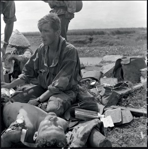 Le médecin lieutenant Patrice de Carfort, du 8e bataillon de parachutiste de choc (BPC), porte assistance au sergent Camille Lambert, mourant suite à l'explosion d'une mine à Cad Khe. CE dernier décède le 28 septembre 1953, Indochine, 24-28 septembre 1953 © ECPAD / Pierre Ferrari