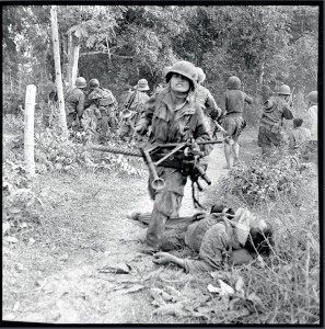 Combats à Ban Hine Siu et Na Pho. Un soldat du 3e BPVN porte une mitrailleuse, peut-être reprise à un camarade tombé au combat, Indochine, 5-9 janvier 1954 © ECPAD / Pierre Ferrari