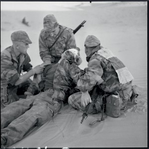 Bataille de Timimoun : mortellement blessé au combat, le jeune parachutiste Jacques Schneidenbach, âgé de vingt ans est entouré par ses camarades du  RPC, Hassi-Rhambou, Algérie, 21 novembre 1957 © ECPAD / Marc Flament