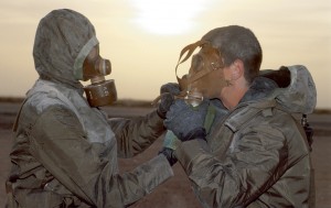 Lors d'un exercice de lutte contre les agents NBC (Nucléaires, bactériologiques et chimiques) au camp du roi Khaled, deux soldats s'entraînent aux procédures de port de la tenue de protection, Arabie Saoudite, novembre 1990© ECPAD / Michel Riehl